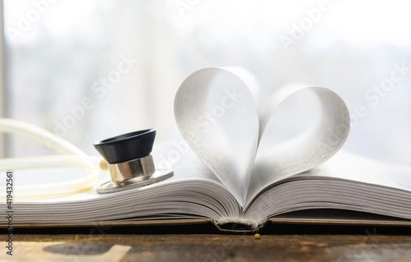 Obraz An open book. The pages are folded in the shape of a heart. A stethoscope pressed against the pages. Concept-education, the pulse of literature.