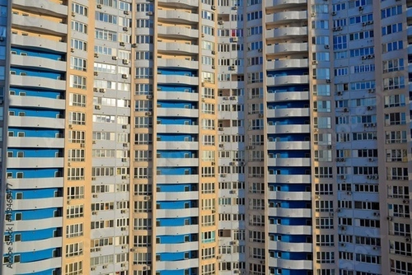 Fototapeta Facade of high-rose block of flats . Windows and balconies  