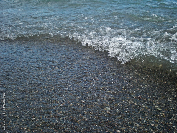 Fototapeta Coastal wave on the background of sea pebbles