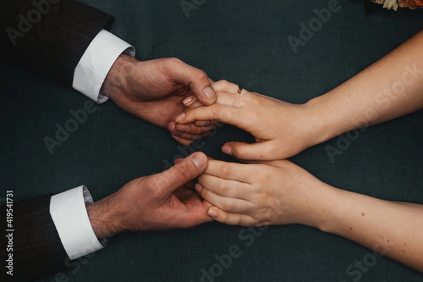 Fototapeta a man and a woman hold hands while sitting at a table