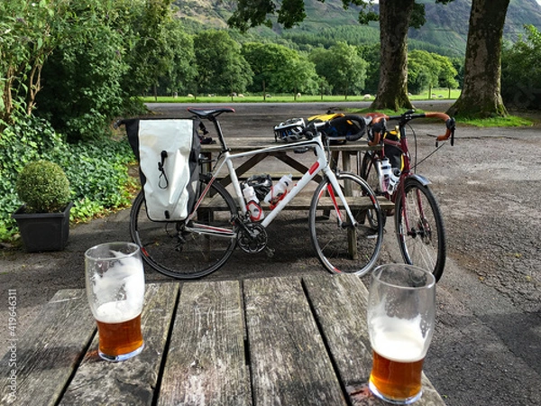 Fototapeta Pair of pints in pub beer garden in the Lake District well earned after a long cycle