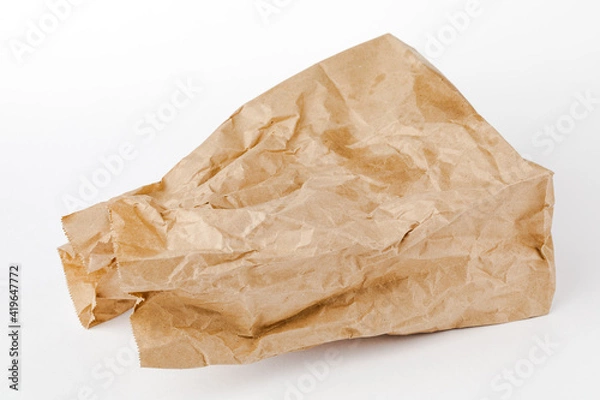 Fototapeta Crumpled paper bag with greasy spots on a white isolated background. Recycling of secondary waste