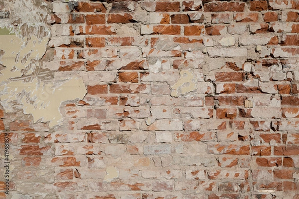 Fototapeta Damaged stone wall with different structure and color, empty facade with grey cement, space for text on the background