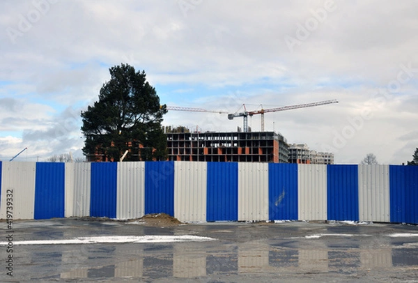 Fototapeta The process of building a multi-storey residential building made of red brick.