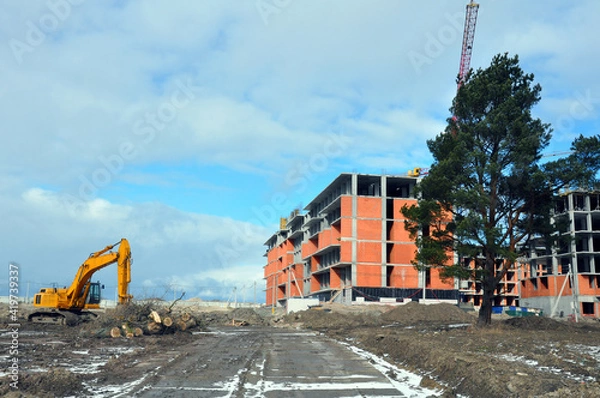 Fototapeta The process of building a multi-storey residential building made of red brick.