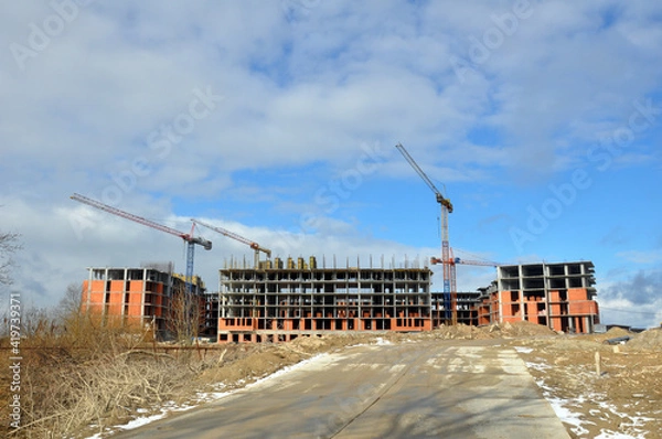 Fototapeta The process of building a multi-storey residential building made of red brick.