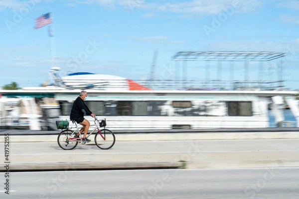 Fototapeta Man on Bicycle Wearing Mask with Motion Blur 