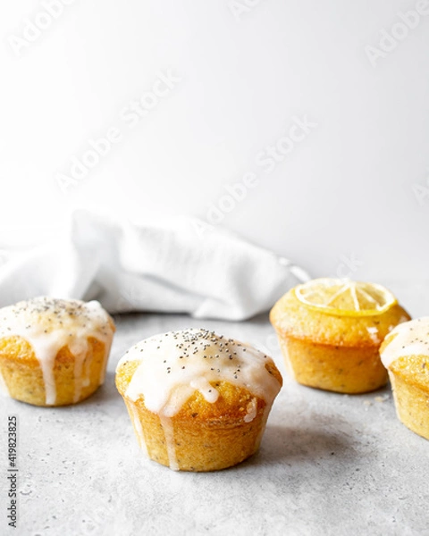 Obraz Lemon Poppy Seed Muffins on a concrete worktop and bright grey background.