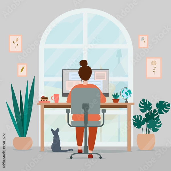 Obraz Woman working at home on computer. Cozy creative workplace homeoffice with plants, paintings and cat. Freelance concept.