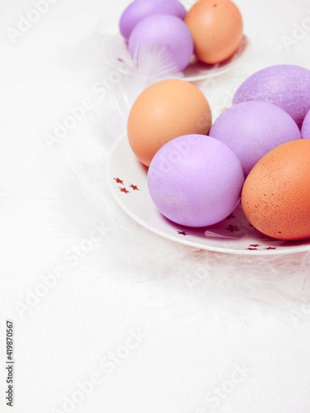 Fototapeta Colored eggs on plate with on white background. Copy space.  Easter concept.