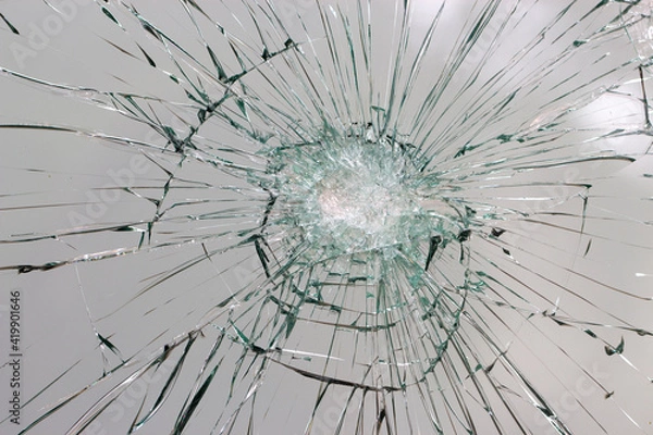 Fototapeta Cracks on the glass on a white background.