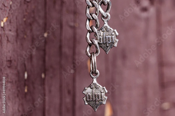 Obraz Metal keychain with a chain on a background of old brown doors