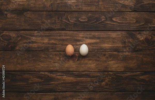 Obraz two different colored chicken eggs on wooden background