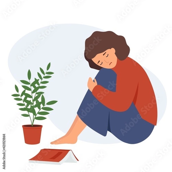 Obraz The girl is sitting next to a flower and a book. A woman is sad alone, with her head on her knees.
