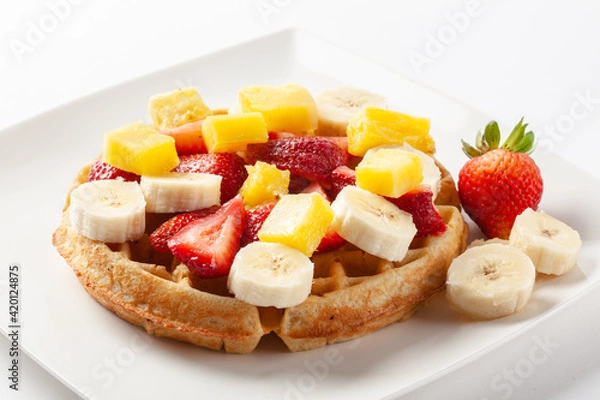 Fototapeta Waffle topped with strawberry banana and orange