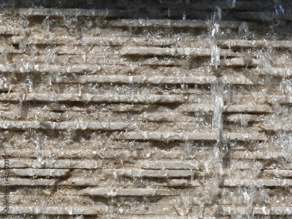 Fototapeta Water trickling down stone surface