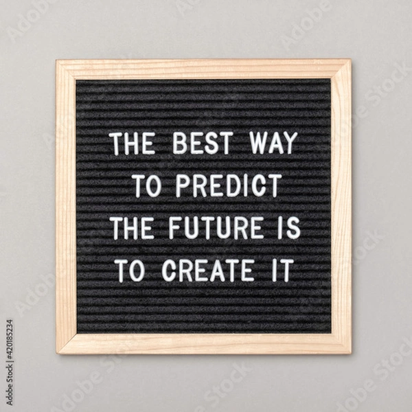 Fototapeta The best way to predict the future is to create it. Motivational quote on letter board, gray background. Concept inspirational quote of the day. Front view