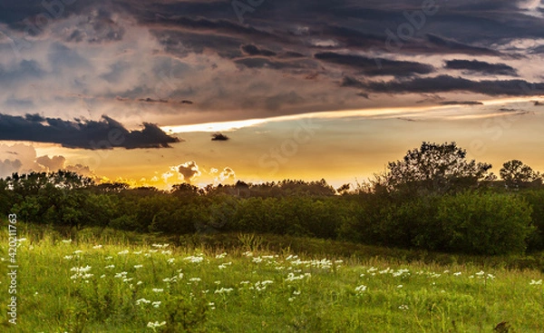 Obraz Thunderstorm clouds over a rural landscape at sunset