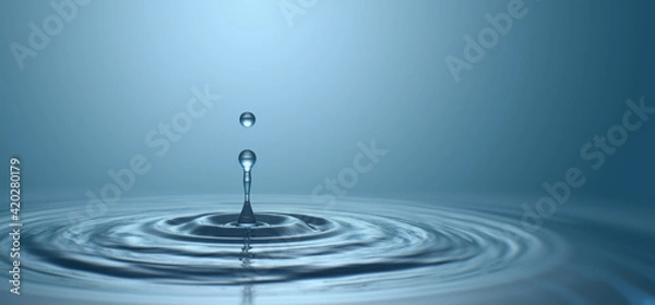 Fototapeta Water drop with droplet and rings on surface bluish background