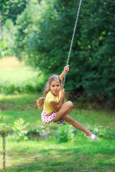 Obraz Portrait of Beautiful little girl Is swinging and playing at summer park. Soft focused
