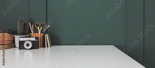 Obraz Home office desk with dark green wall and white table mock up.	