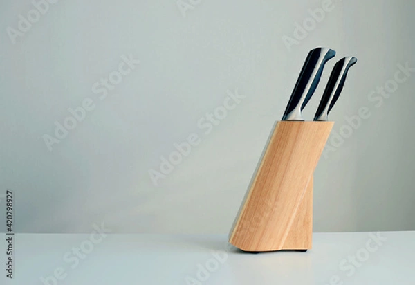 Fototapeta set of knives on a wooden stand on a white background, copy space