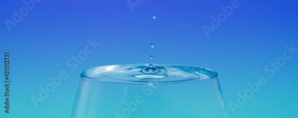Fototapeta water splash in a cup with gradient blue background