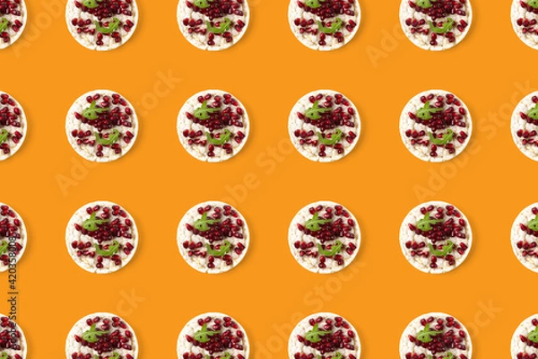 Fototapeta Abstract background from galett. Healthy breakfast with rice cake and pomegranate on black flat lay. Pop art