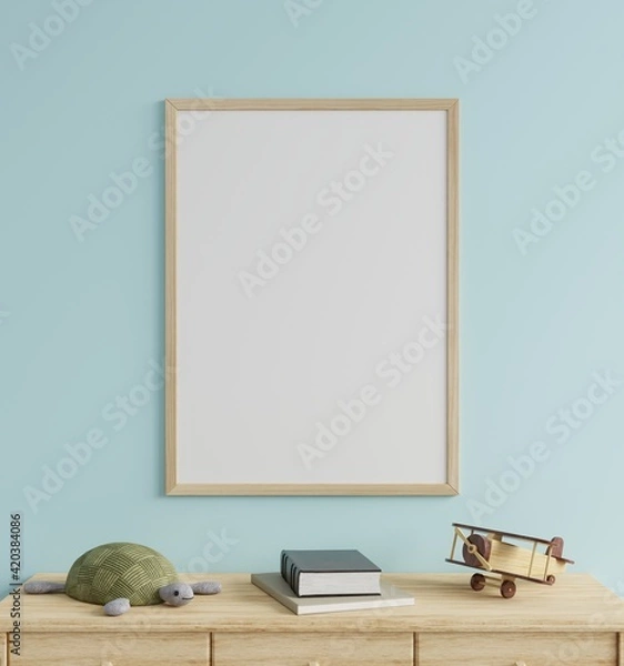 Obraz Mock up photo frame in the children's room on a blue wall, decorated with a tortoise doll and a wooden plane on the table.3d rendering.