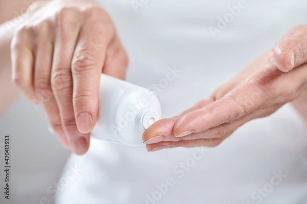 Fototapeta クリームを手に出す中年の日本人女性