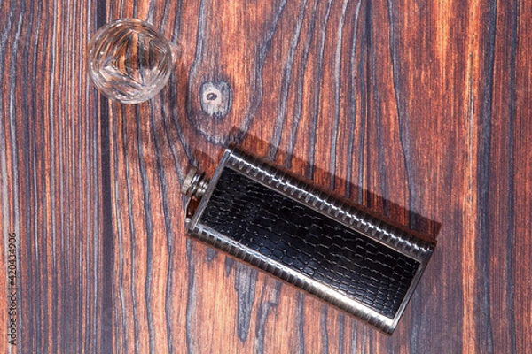 Obraz Hip flask and glass on a wooden table
