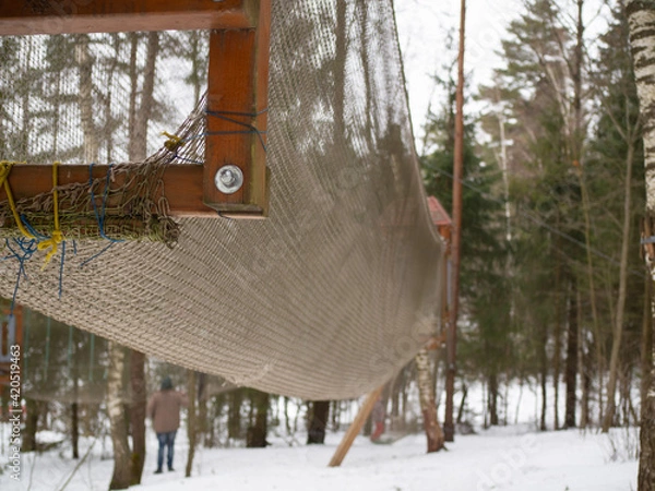 Obraz rope town. The attraction is a grid with obstacles between the trees.