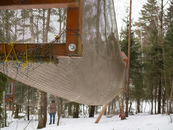 Obraz rope town. The attraction is a grid with obstacles between the trees.
