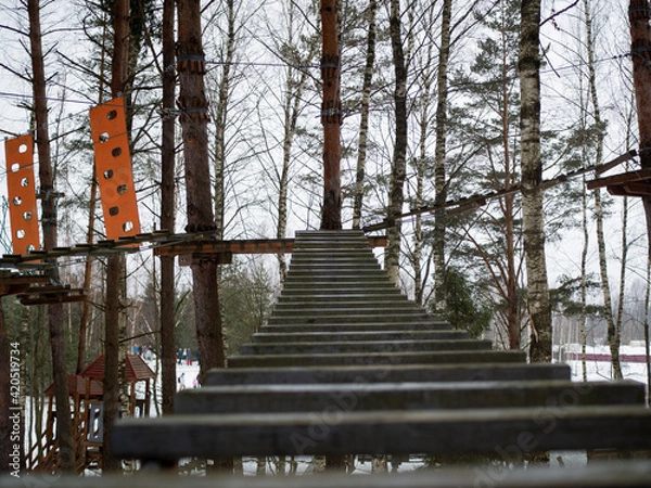 Obraz rope town. a wooden staircase between the trees. steps up