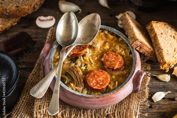 Fototapeta Christmas cabbage soup in ceramic bowl on natural wooden background.