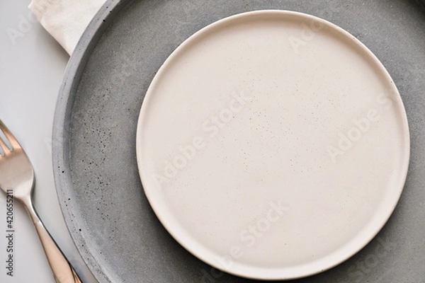 Fototapeta empty grey plates on a table with fork and knife. spring menu concept. trendy nordic minimal style tableware. restaurant menu mock up, scandinavian tableware design, top view