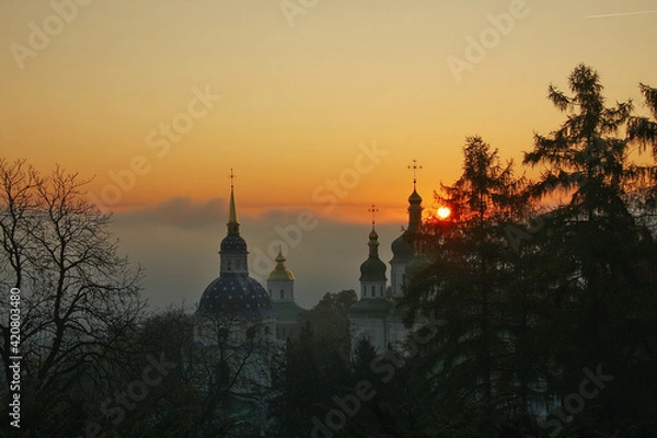 Fototapeta Orthodox church in the morning fog at dawn in the middle of the park