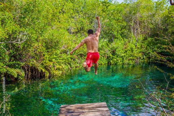 Obraz man jumping into a cenote in the Riviera Maya
