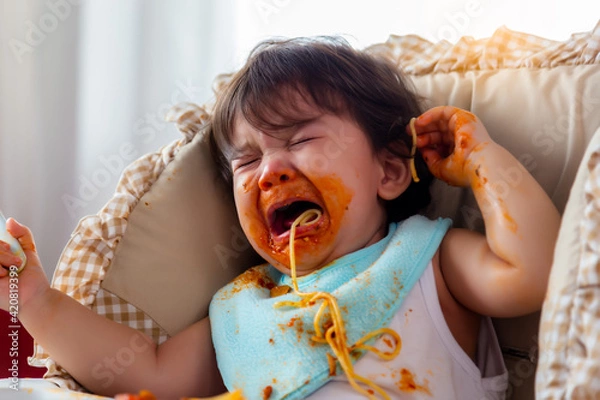 Obraz Wayward little toddler child or infant baby crying that don't want eating food on baby chair Cute infant children get hungry and want new food Children get dirty Kid get tantrum Baby is stubborn baby