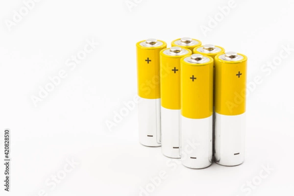 Obraz Photo of gray-yellow alkaline AA batteries on white background. Recycling of rechargeable NiMH batteries. The most popular size of accumulators. Copy space.