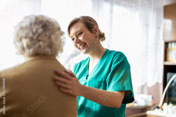Obraz Friendly nurse supporting an elderly lady
