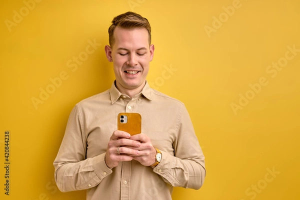 Fototapeta nice european man holding smartphone in hands creating social strategy influencer thinking
