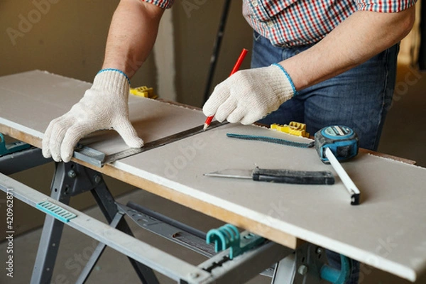 Obraz Builder measures and marks drywall sheet