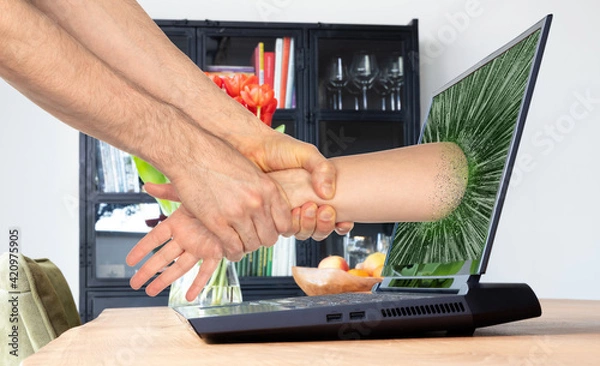 Obraz Man pulling someone through the laptop screen