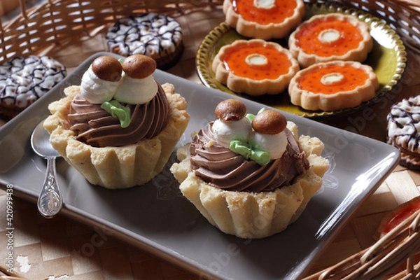 Fototapeta Close-up of different beautiful sweet cakes with cream and marmalade on the table