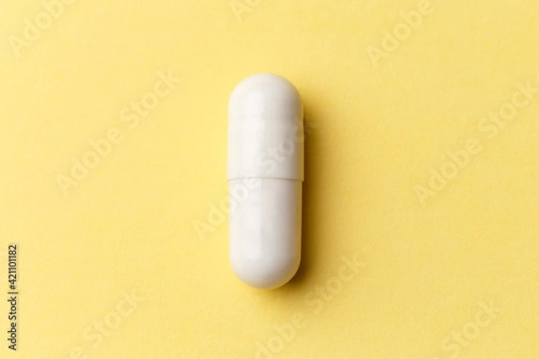 Obraz Pharmaceutical medicine pills, tablets and capsules on colourful yellow background. Top view. Flat lay. Copy space. Medicine concepts. Minimalistic abstract concept. White medicine capsule