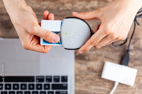 Fototapeta A personal identity verification (PIV) card is used to login to a workspace computer. The card containing a chip is attached to the laptop through card reader preventing unauthorized network access.