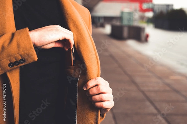 Fototapeta Man taking a wallet from the inside pocket of his coat