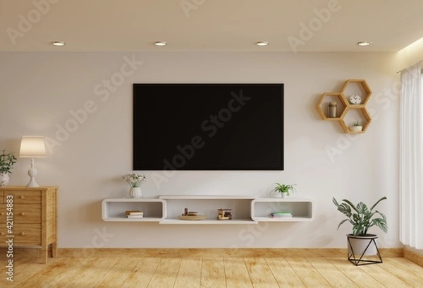 Obraz TV in the living room on a white wall by the window, decorated with plants, vases, flowers, toys and lamps.3d rendering.
