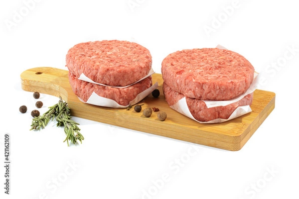 Fototapeta Raw beef patties for making a burger.Isolated on a white background.Selective Focus.